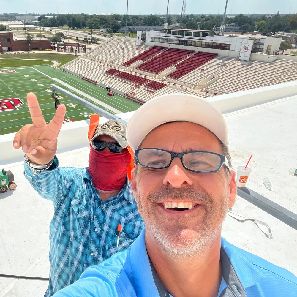 Two RoofPro team members pictured together on a commercial roof